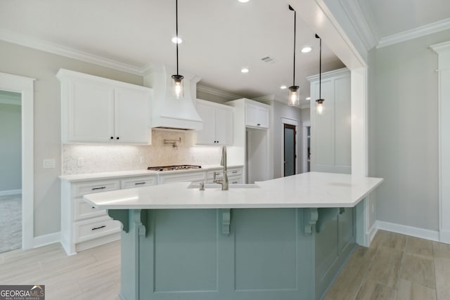 kitchen featuring sink, pendant lighting, white cabinets, and a large island