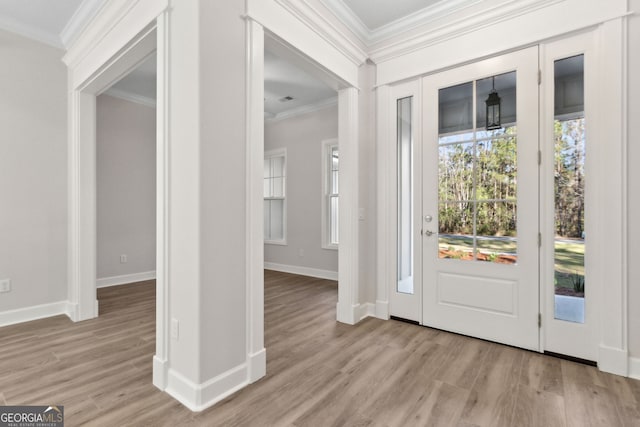 foyer featuring crown molding, wood finished floors, and baseboards