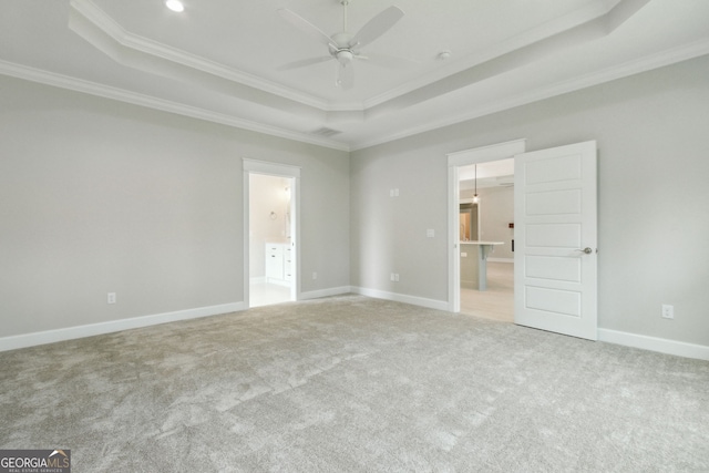 carpeted spare room with crown molding, ceiling fan, and a tray ceiling