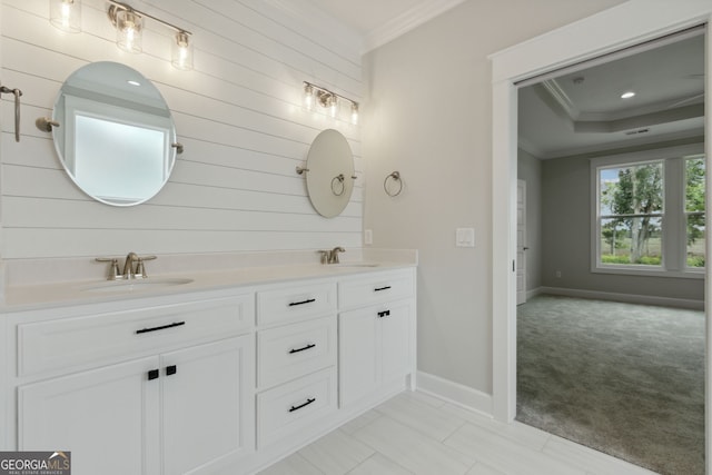 bathroom featuring a raised ceiling, crown molding, and vanity