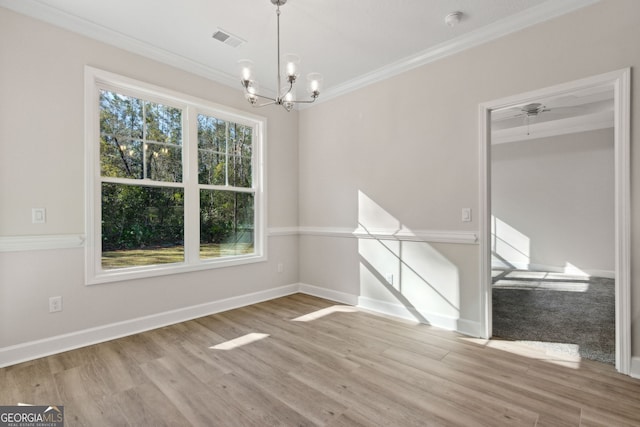 unfurnished dining area featuring crown molding, wood finished floors, visible vents, and a chandelier