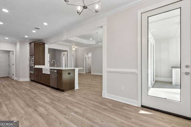 kitchen featuring stainless steel appliances, dark brown cabinets, crown molding, and light countertops