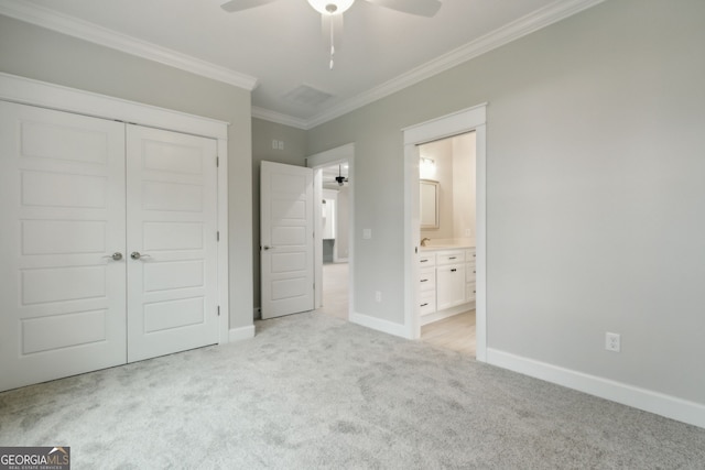 unfurnished bedroom featuring connected bathroom, light colored carpet, ceiling fan, crown molding, and a closet