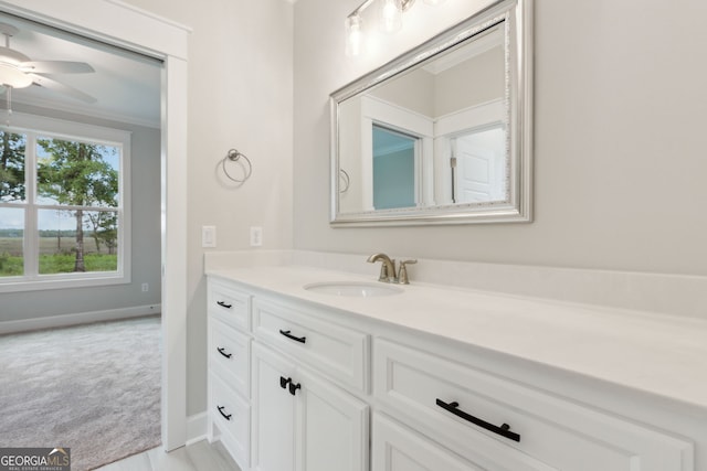 bathroom with crown molding, ceiling fan, and vanity