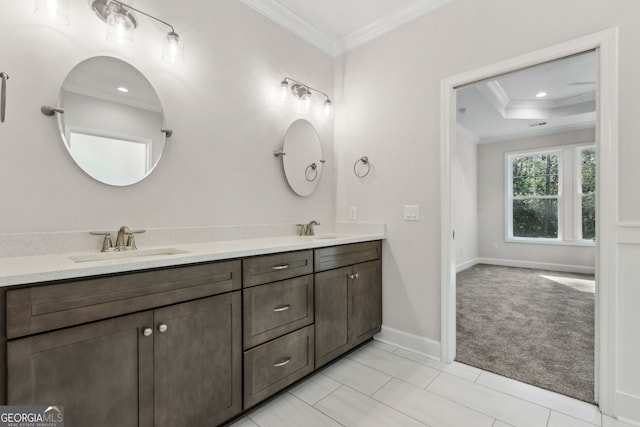 full bathroom featuring double vanity, crown molding, baseboards, and a sink