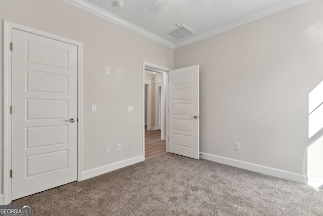 unfurnished bedroom with visible vents, crown molding, baseboards, and carpet floors