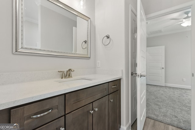 bathroom with vanity, wood finished floors, a ceiling fan, visible vents, and ornamental molding