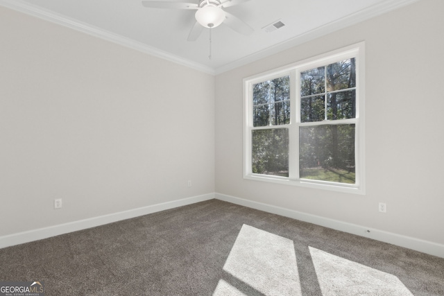 carpeted spare room featuring a ceiling fan, crown molding, baseboards, and visible vents