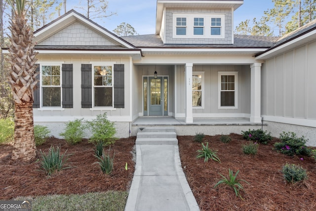 property entrance featuring a porch, board and batten siding, and roof with shingles