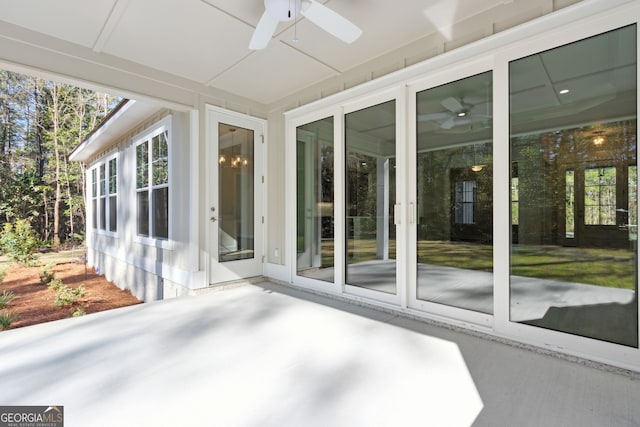 unfurnished sunroom with ceiling fan