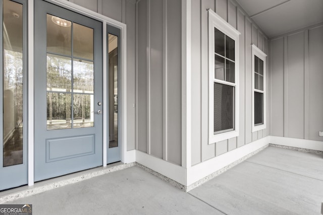 property entrance with board and batten siding and a patio area