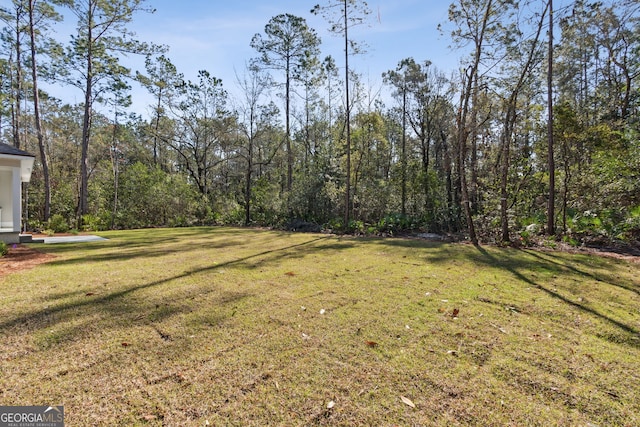 view of yard featuring a forest view