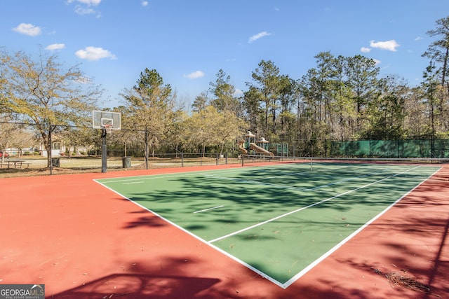 view of tennis court with playground community and fence