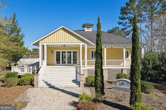 view of front facade featuring a ceiling fan, french doors, stairway, roof with shingles, and covered porch