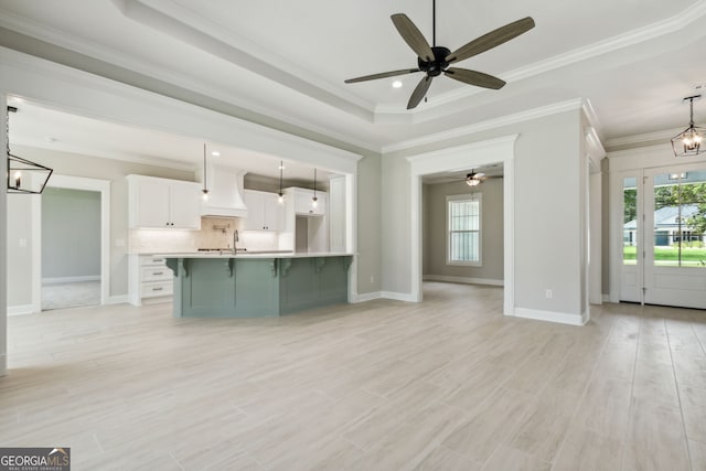 kitchen featuring a healthy amount of sunlight, hanging light fixtures, sink, and white cabinets