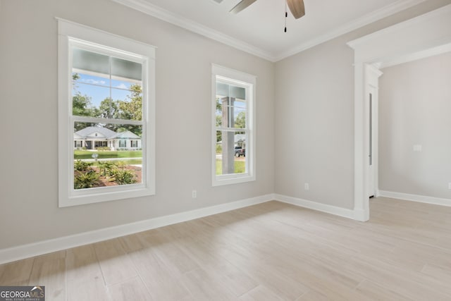 spare room featuring crown molding, a wealth of natural light, and light wood-type flooring