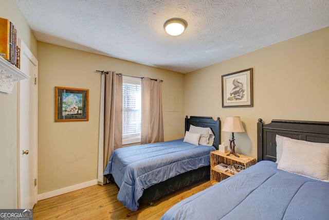 bedroom featuring light hardwood / wood-style floors and a textured ceiling