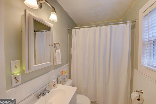 bathroom featuring vanity, toilet, a textured ceiling, and walk in shower