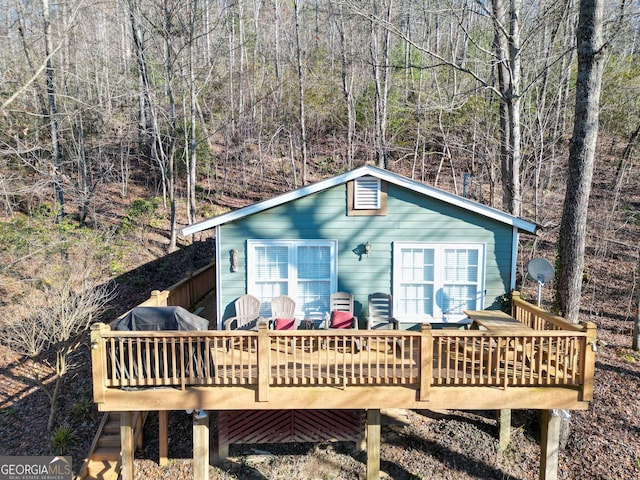 rear view of property featuring a wooden deck