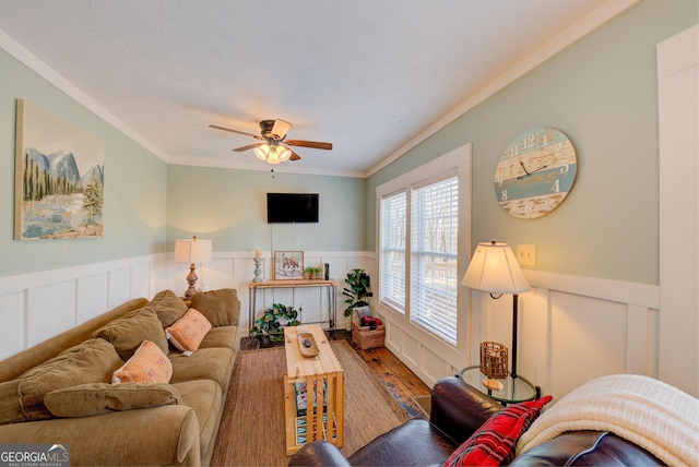 living room featuring ceiling fan, hardwood / wood-style floors, a textured ceiling, and ornamental molding