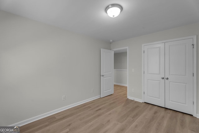 unfurnished bedroom featuring a closet and light hardwood / wood-style flooring