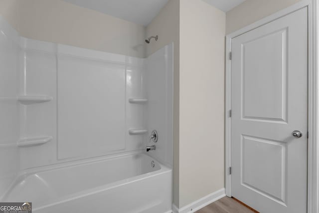 bathroom featuring bathtub / shower combination and hardwood / wood-style flooring