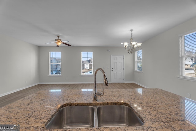 kitchen with ceiling fan with notable chandelier, plenty of natural light, hanging light fixtures, and sink