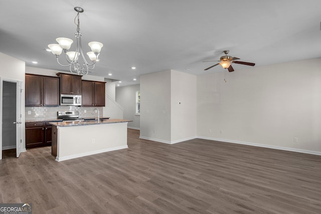 kitchen with sink, decorative light fixtures, a kitchen island with sink, dark brown cabinets, and appliances with stainless steel finishes