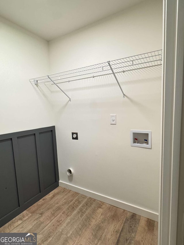 clothes washing area with washer hookup, electric dryer hookup, and wood-type flooring