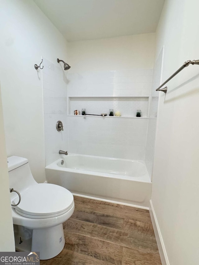 bathroom featuring toilet, washtub / shower combination, and hardwood / wood-style flooring