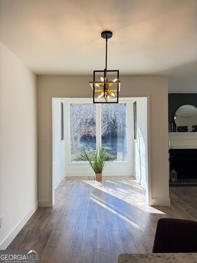 unfurnished dining area featuring a chandelier and hardwood / wood-style flooring