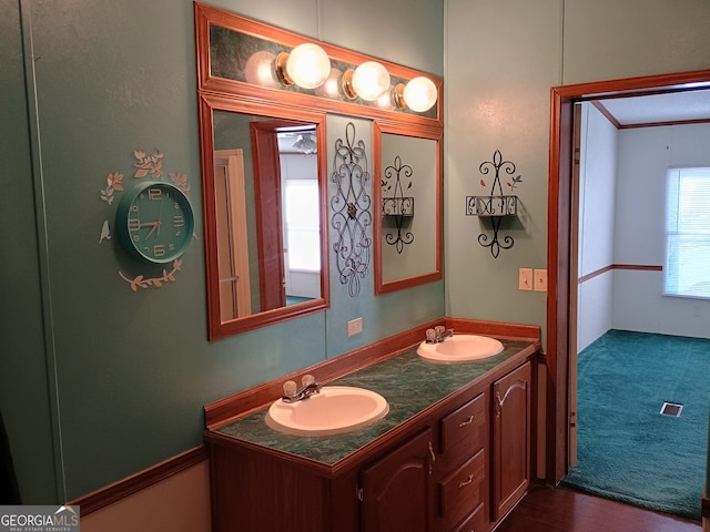 bathroom featuring hardwood / wood-style floors, vanity, and crown molding