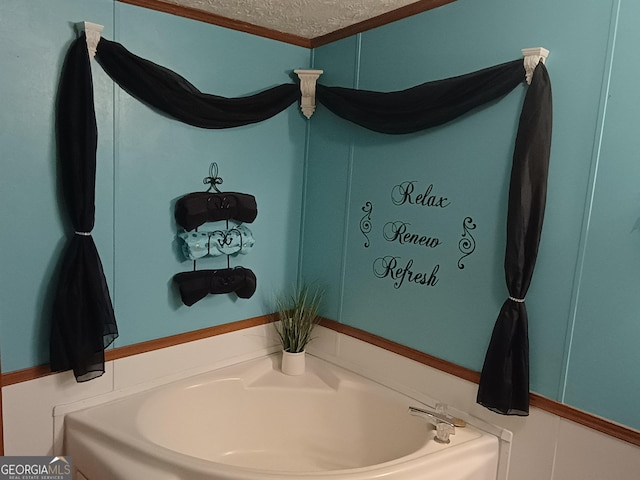 bathroom with a washtub and a textured ceiling