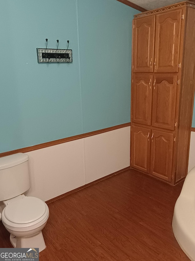 bathroom with hardwood / wood-style flooring and toilet