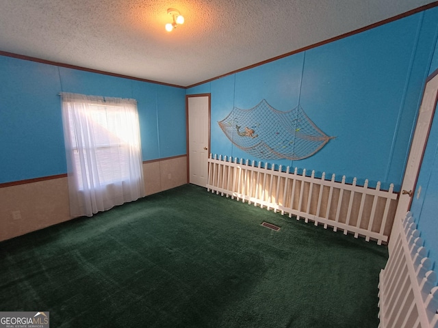 carpeted spare room with a textured ceiling and ornamental molding