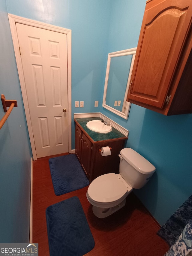 bathroom with hardwood / wood-style floors, vanity, and toilet