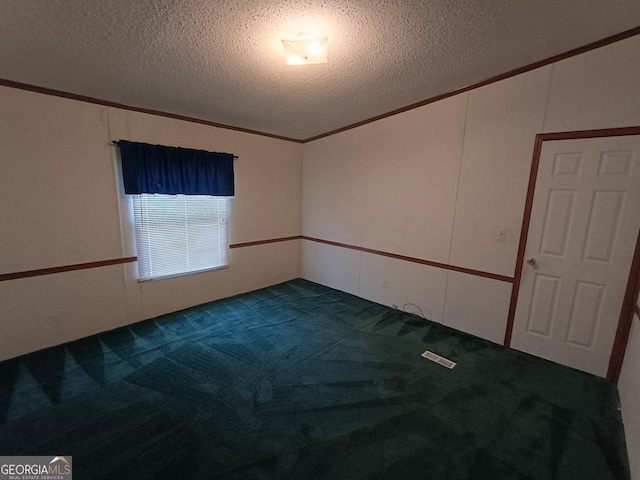 carpeted spare room with a textured ceiling