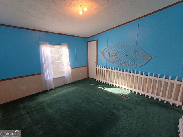 carpeted spare room featuring a textured ceiling and ornamental molding