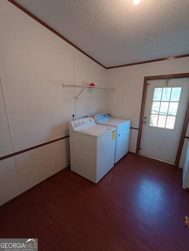 washroom featuring washer and dryer, dark hardwood / wood-style flooring, and a textured ceiling