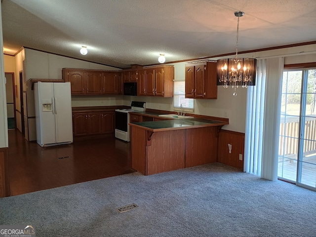 kitchen featuring kitchen peninsula, wood walls, pendant lighting, white appliances, and a kitchen bar