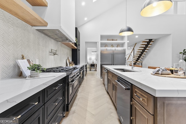 kitchen featuring light stone countertops, sink, hanging light fixtures, custom range hood, and high end appliances