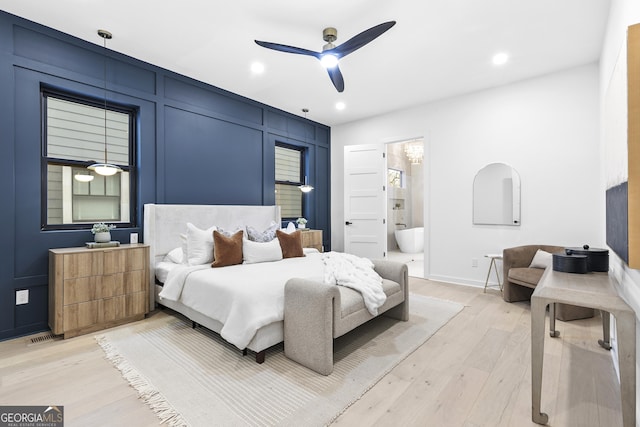 bedroom with light hardwood / wood-style floors, ceiling fan, and ensuite bathroom