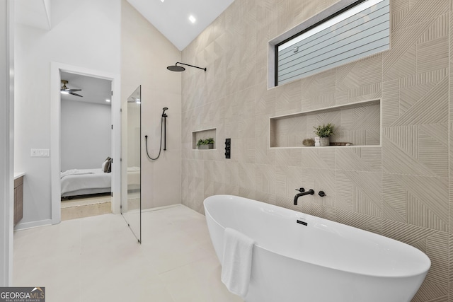 bathroom featuring lofted ceiling, plus walk in shower, tile patterned floors, ceiling fan, and tile walls