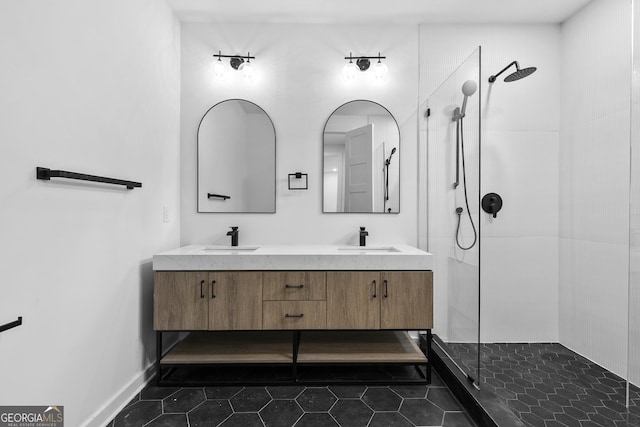 bathroom with tile patterned floors, vanity, and a tile shower