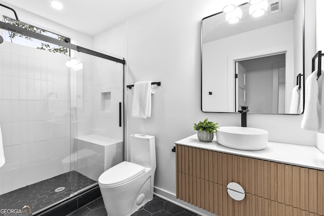 bathroom featuring tile patterned floors, vanity, toilet, and a shower with shower door