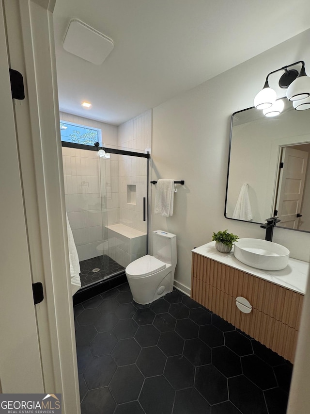 bathroom with tile patterned floors, a shower with door, vanity, and toilet