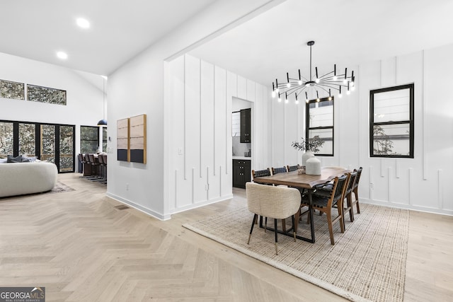 dining space with light parquet flooring and a chandelier