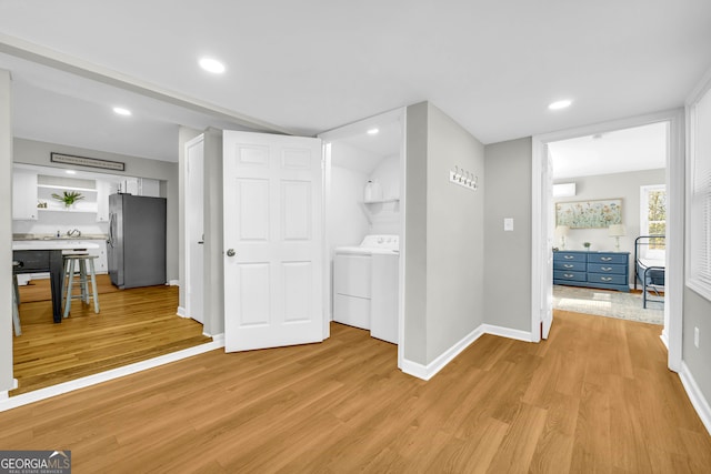 hall featuring washer / clothes dryer and light hardwood / wood-style floors