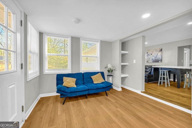 sitting room featuring built in features and light hardwood / wood-style flooring