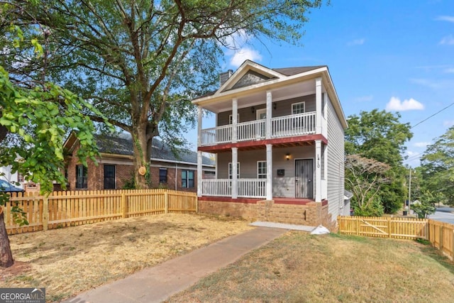 view of front of home with covered porch, a balcony, and a front lawn